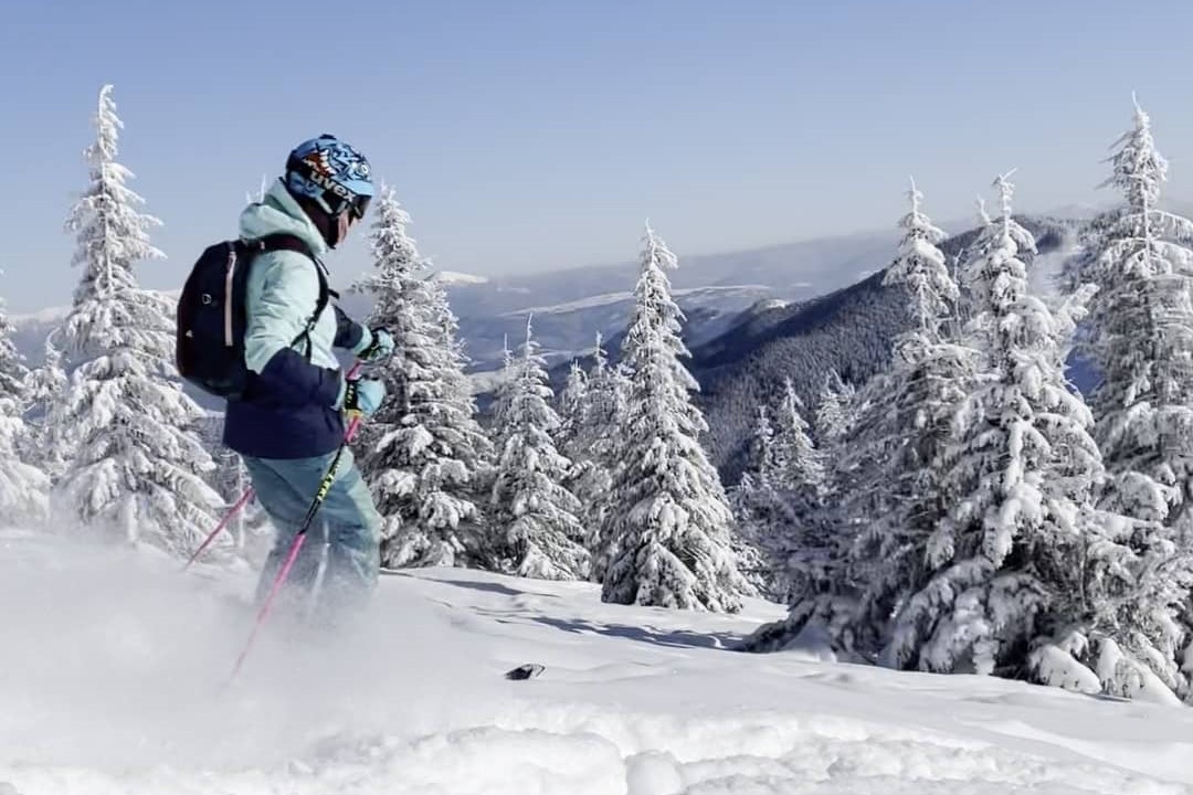 The woman skiing in mountains